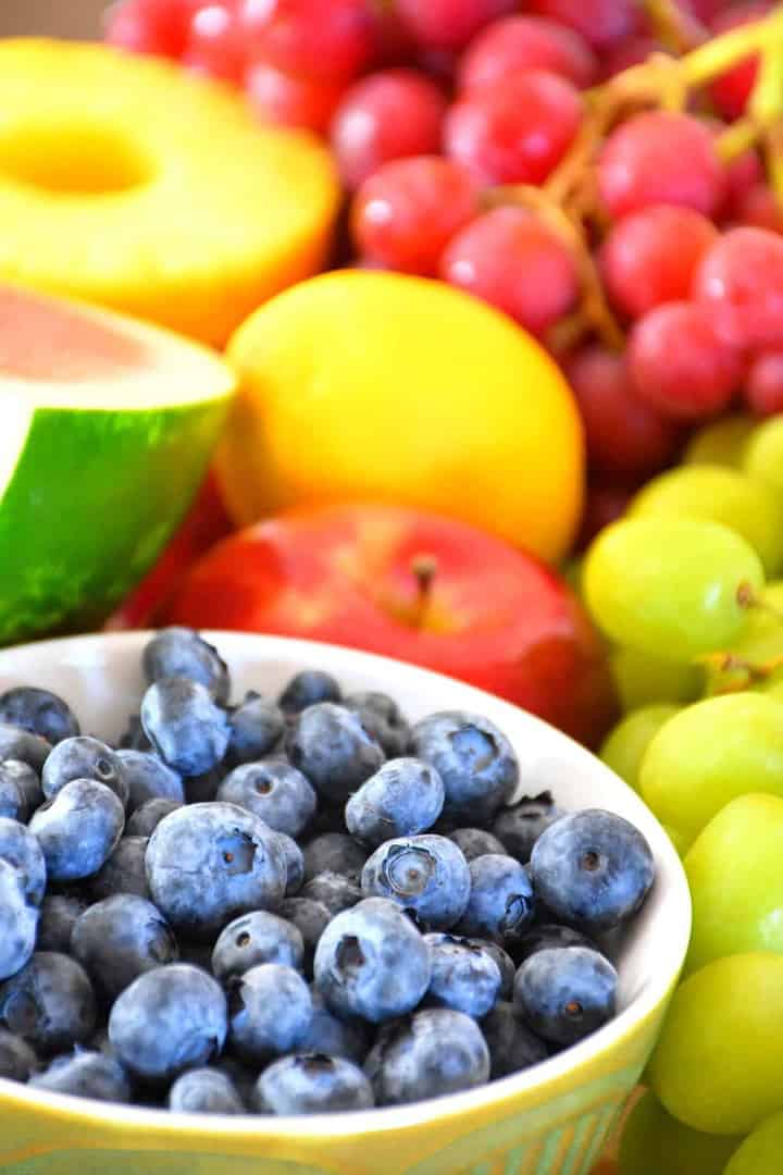 Tous les fruits utilisés dans la recette de salade de fruits santé. Il y a des bleuets, des raisins, des pommes, du melon d'eau, de l'ananas et du citrons.