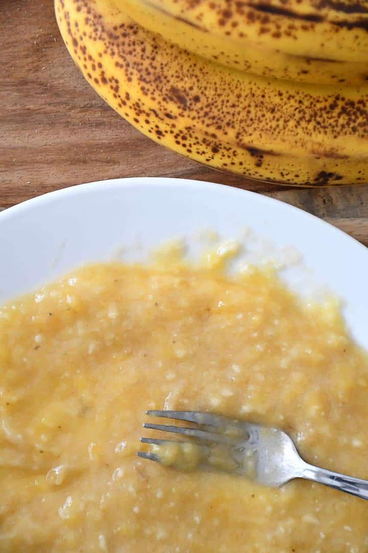 Gros plan sur des bananes réduites en purée à la fourchette.