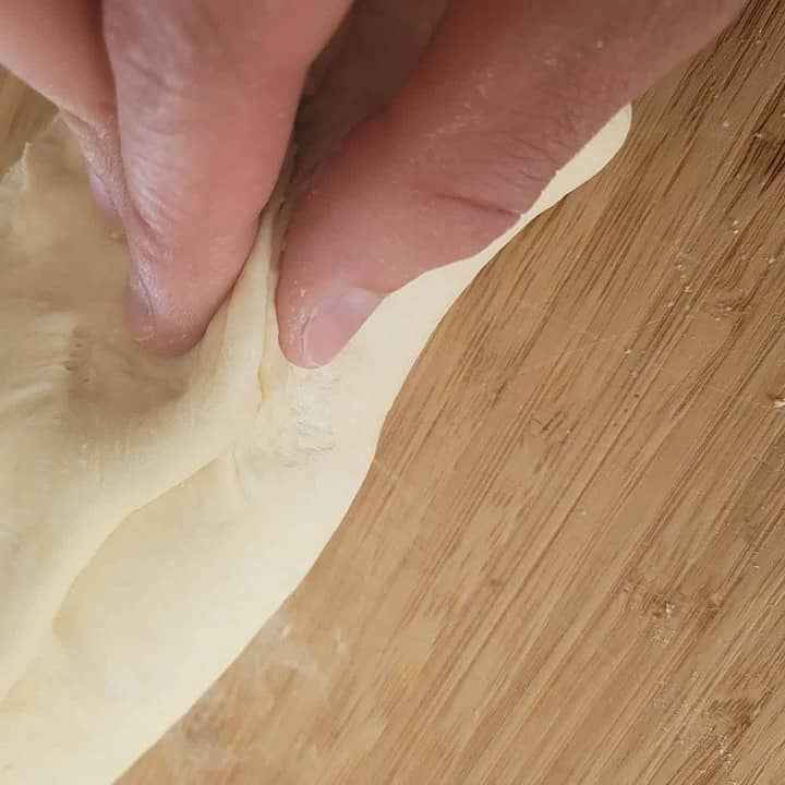 Pincez la pâte à pain blanc faible teneur en sodium pour faire un rouleau de pâte uniforme.