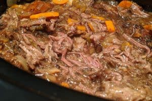 Adding pulled beef in the thickened broth to make it juicier.