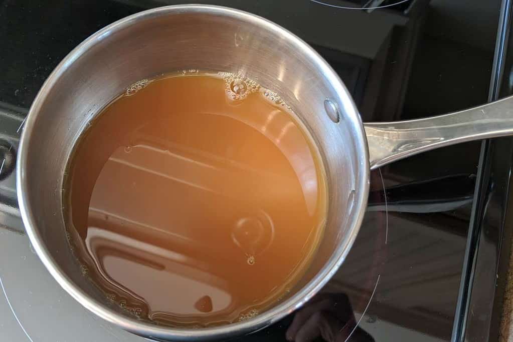 Heating apple juice in a saucepan.