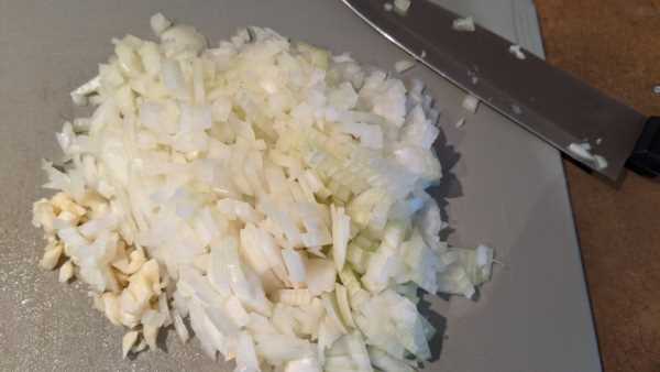 Chopped onions and garlic cloves to add flavor to a kidney friendly soup.