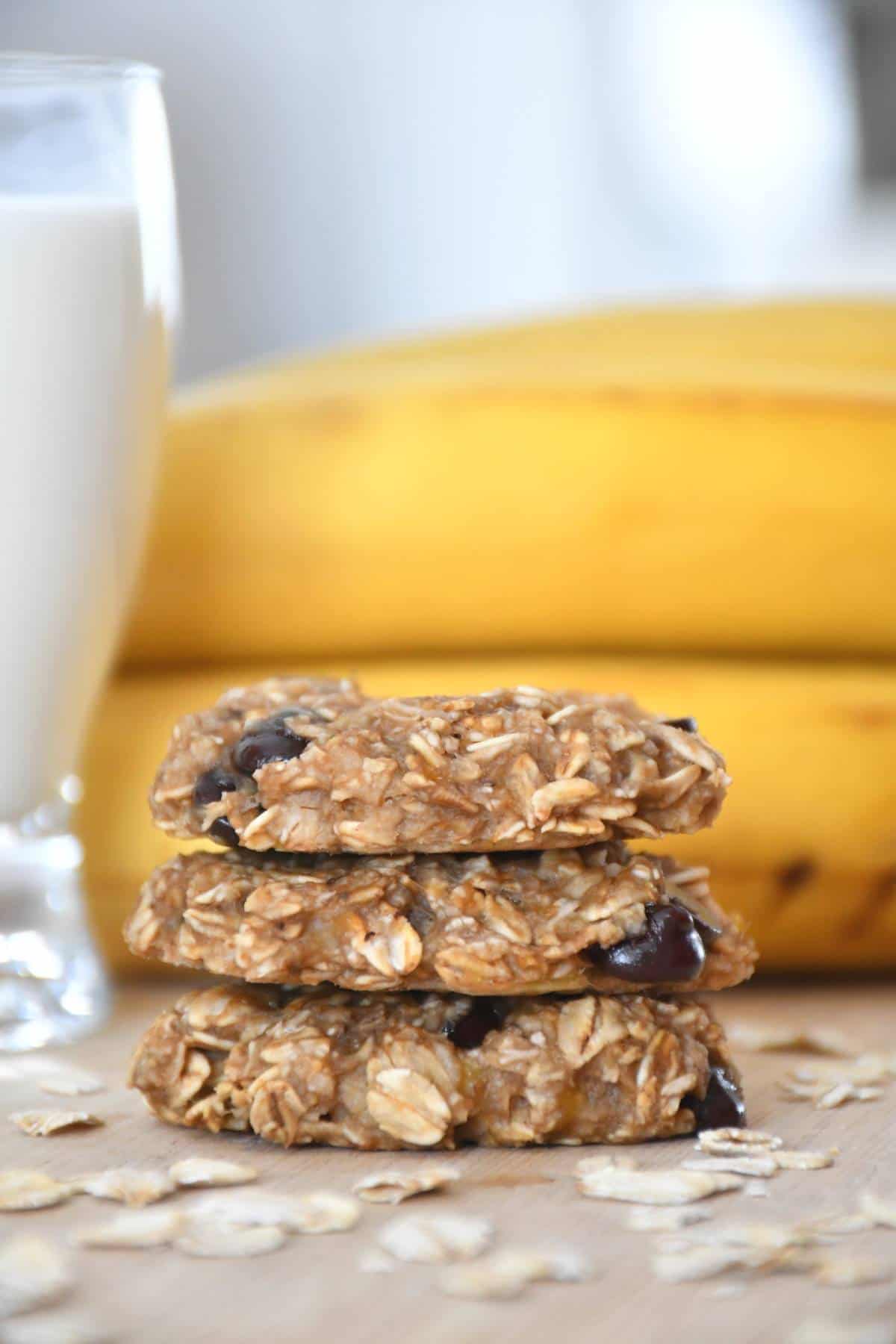 Chewy banana oatmeal chocolate chip cookies with a glass of vegetal beverage.