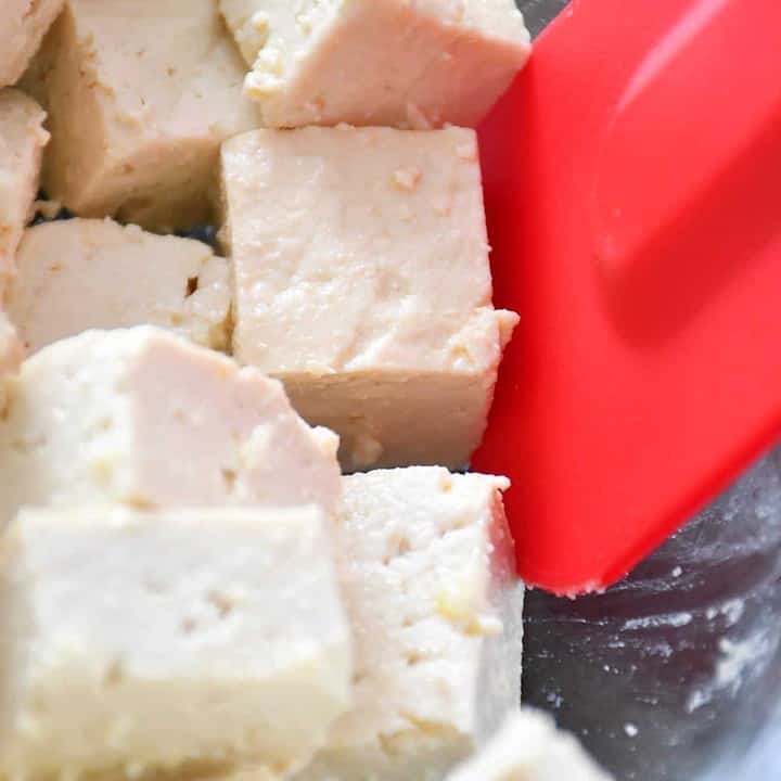 Coating the tofu cube with olive oil and cornstarch.