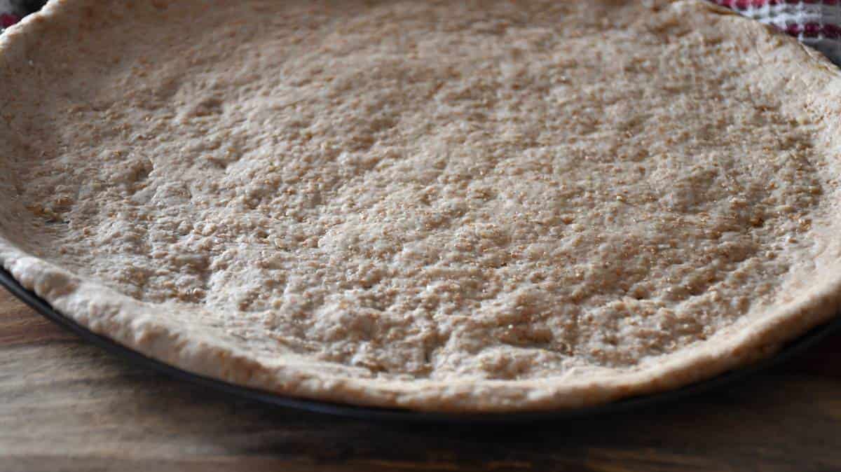 Low sodium whole wheat pizza dough manually shaped and ready to use.