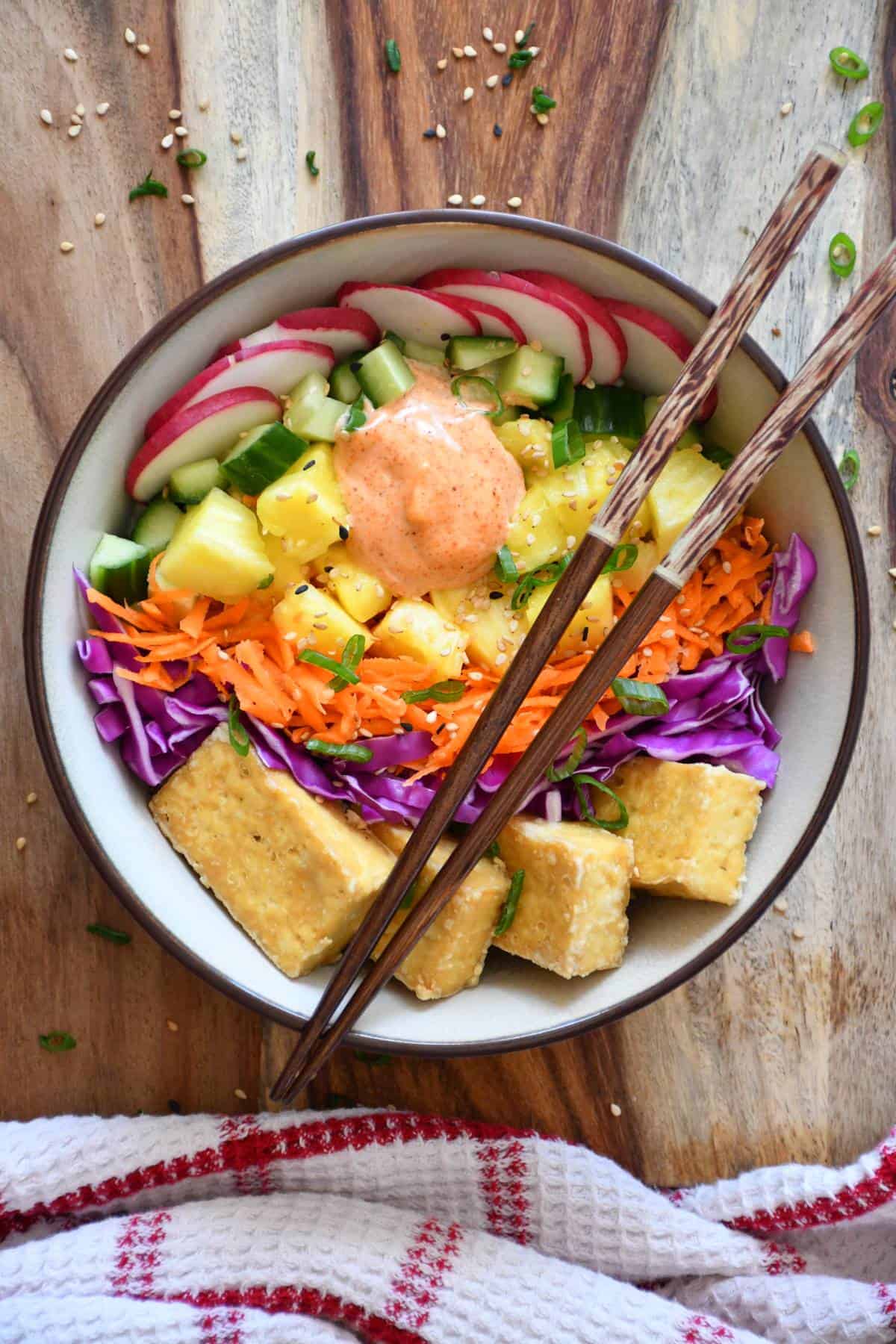 Vegetarian poke bowl made with fresh vegetables, brown rice, baked tofu and paprika sauce.